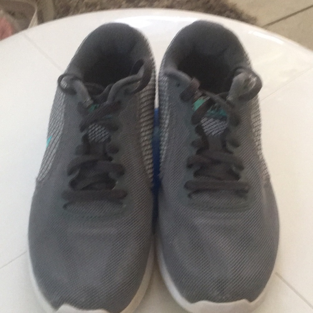 Woman’s Grey/White Revolution Nike Sneakers With Greenish Blue Nike Symbol.